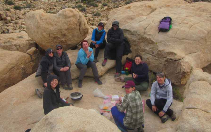 a group of veterans rest on a rocky landscape on an outward bound veterans course